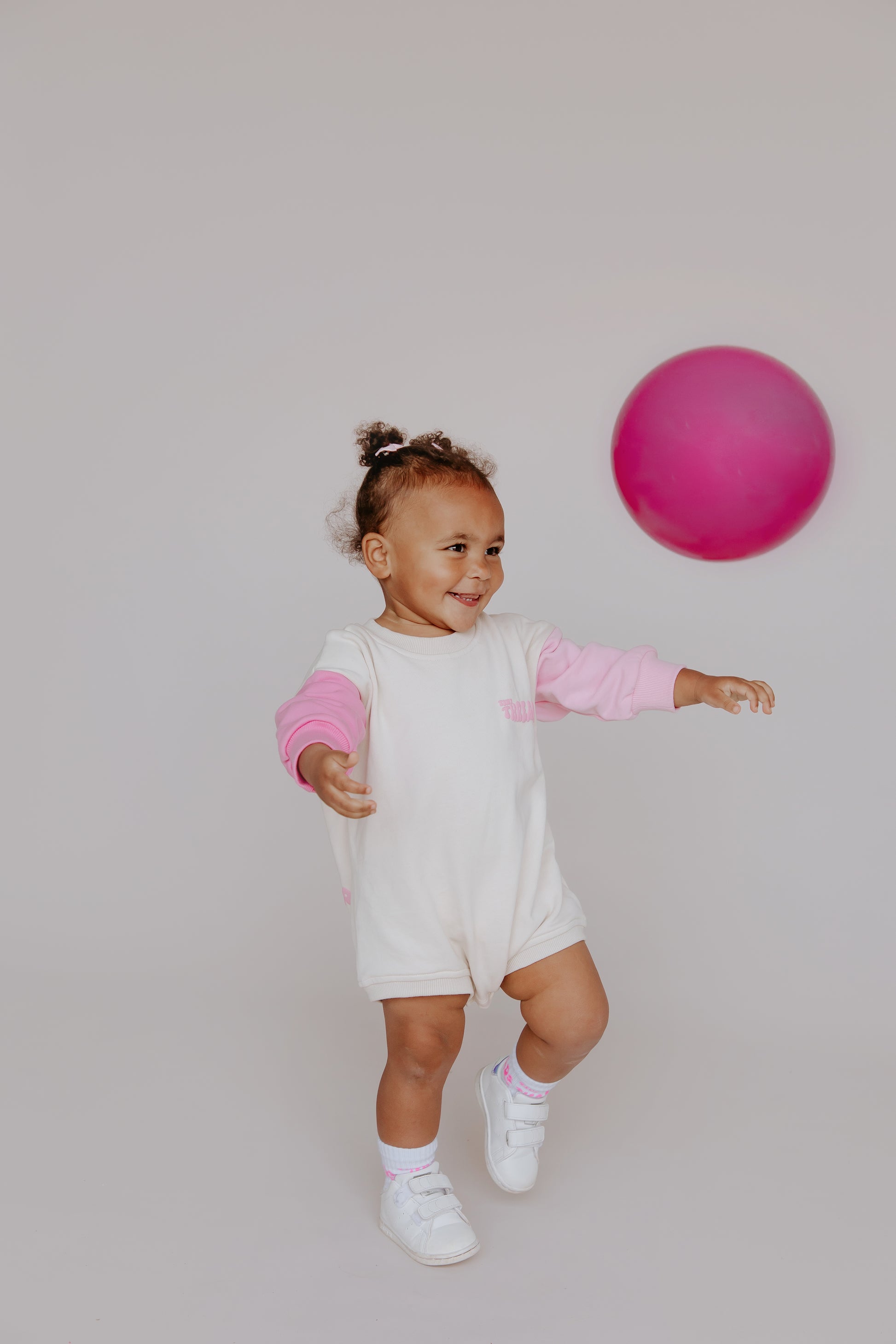 Tiny Threads Co. oversized long sleeve romper in pink, worn by D, aged 26 months