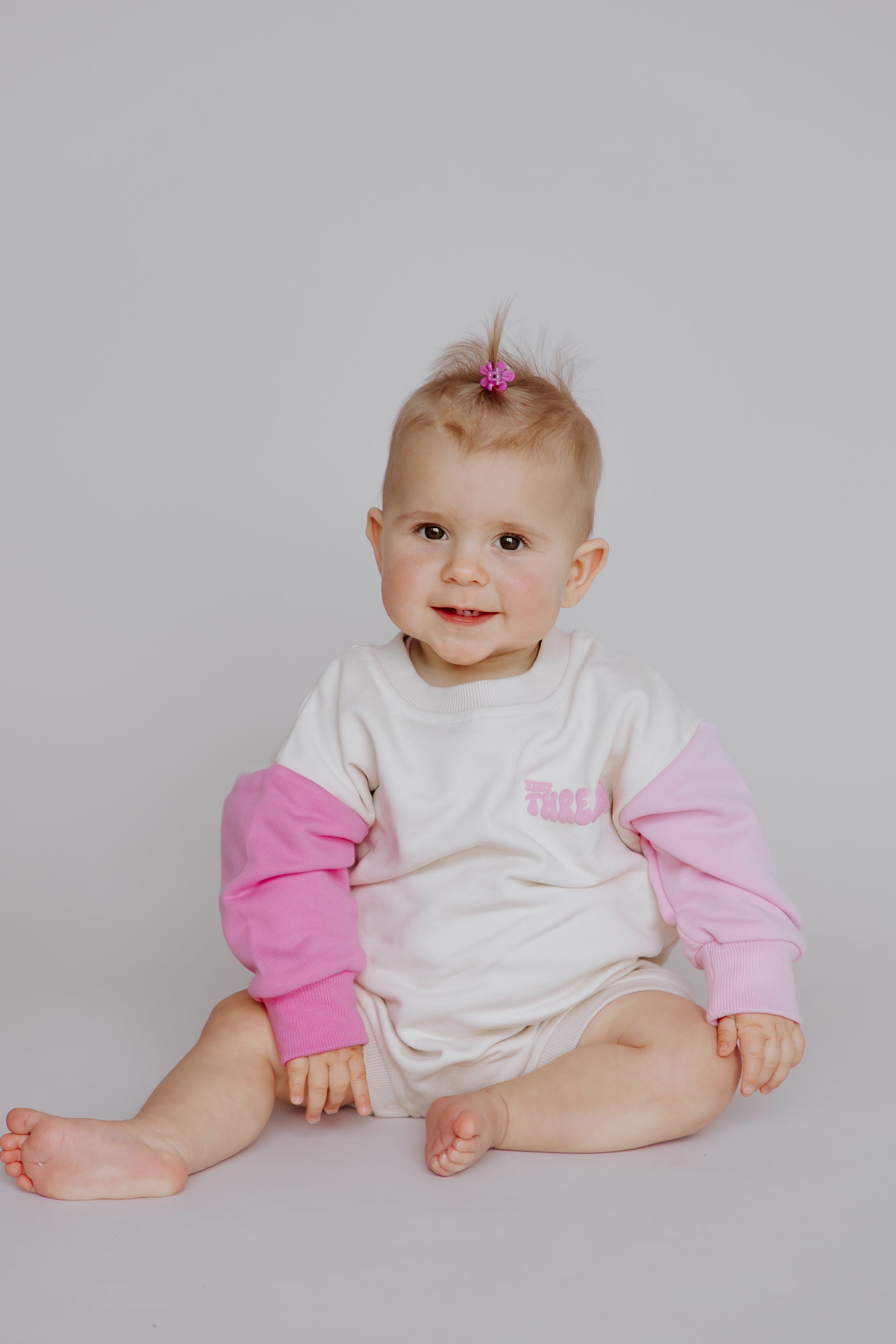 Tiny Threads Co. oversized long sleeve romper in pink worn by L, aged 10 months